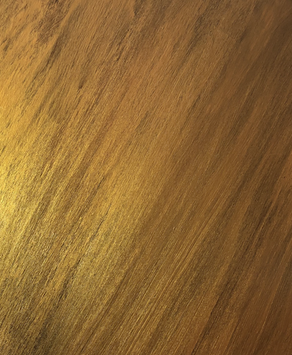 A photo of an ancyrlic on canvas board painting. It has a black underlayer and a brushed gold overlayer that tilts form vertial about 20 degrees. The gold paint looks streaked with black in some places.